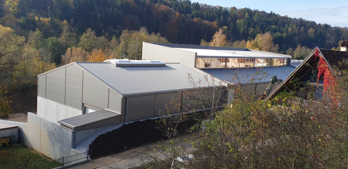 Ein Bild der Lagerhalle. Im Hintergrund ein großer Wald.
